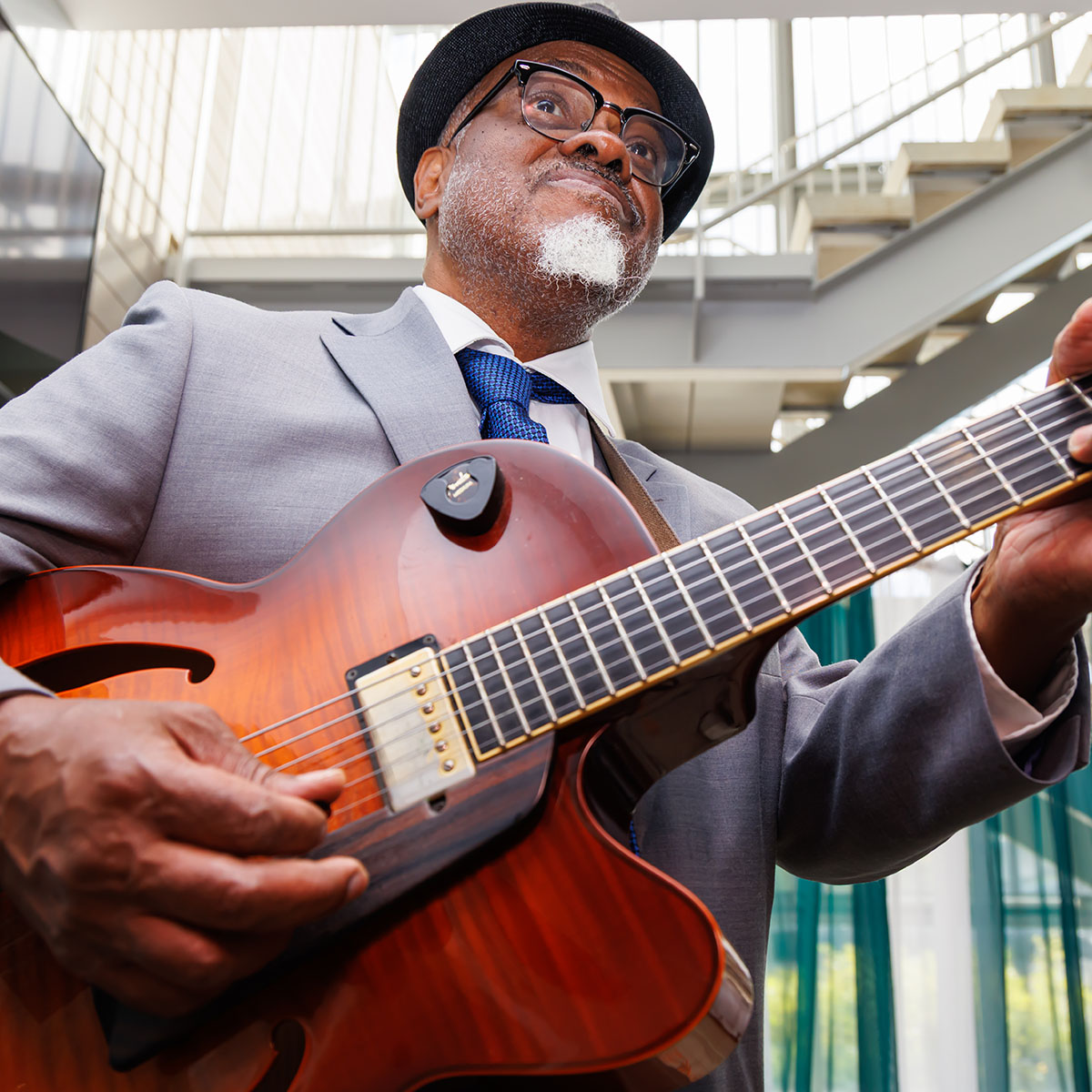 A jazz musician playing guitar during reception