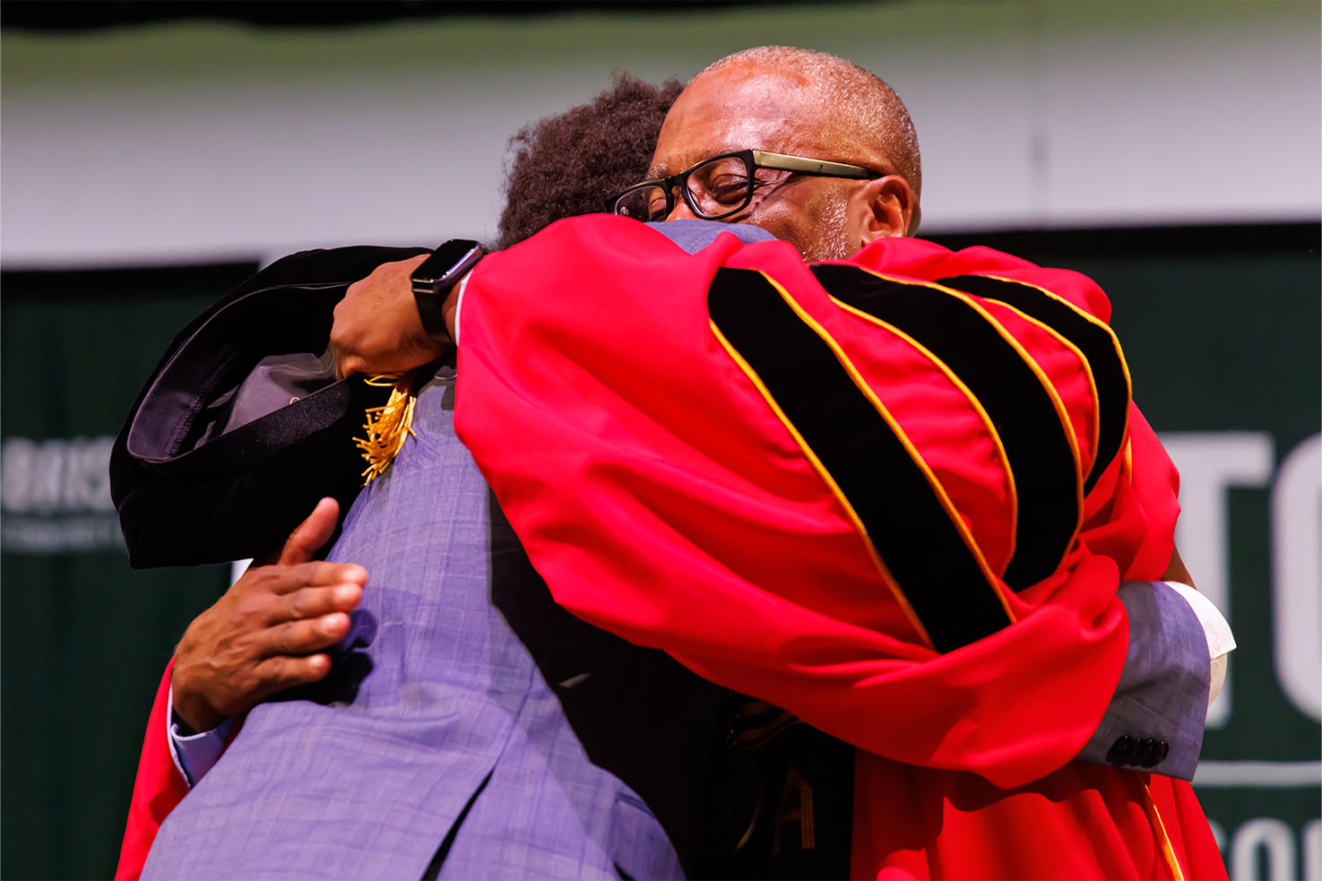 Dr. Harris hugging his son on stage at Inauguration