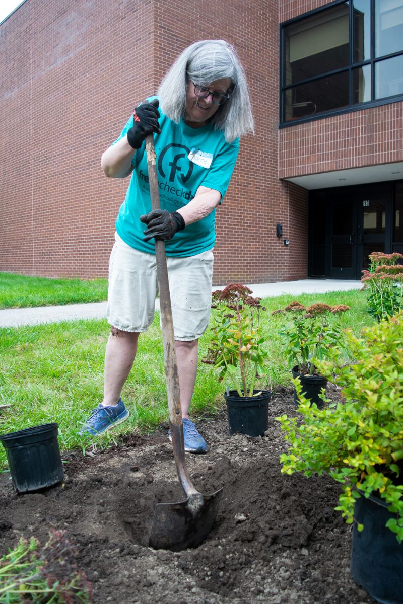 Woman shoveling dirt to plant in