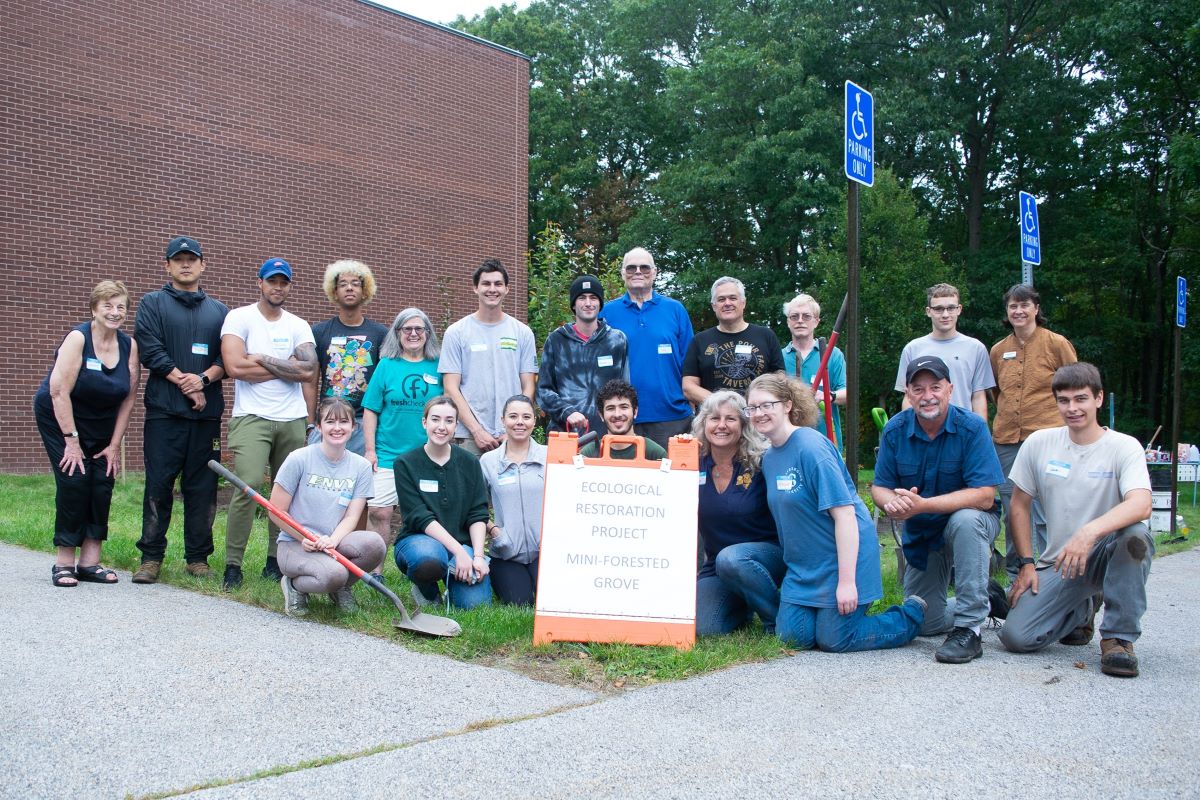 Group of people standing by the newly planted Miyawaki Grove
