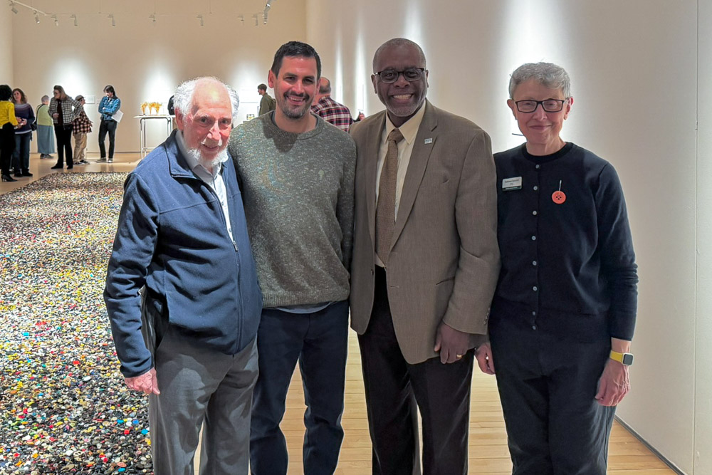 Ron Weisberger, President Harris, and Kathleen Hancock with the selected proposal winner of the Button Project, Zach Horn.