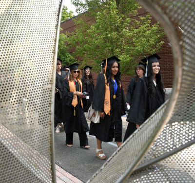 group of graduates at procession near artwork