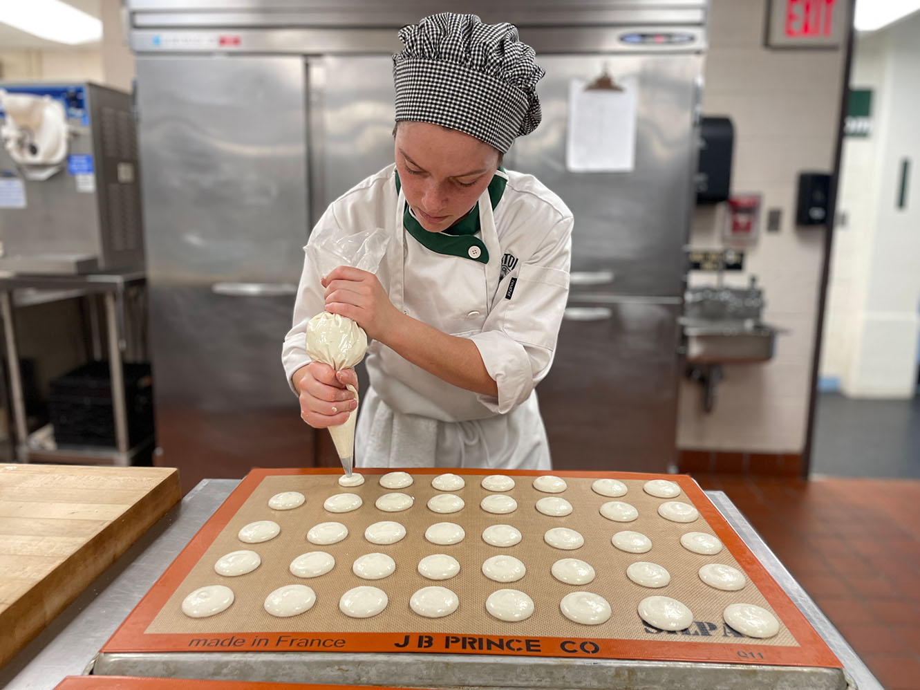 Baking and pastry arts student at Bristol piping a pastry