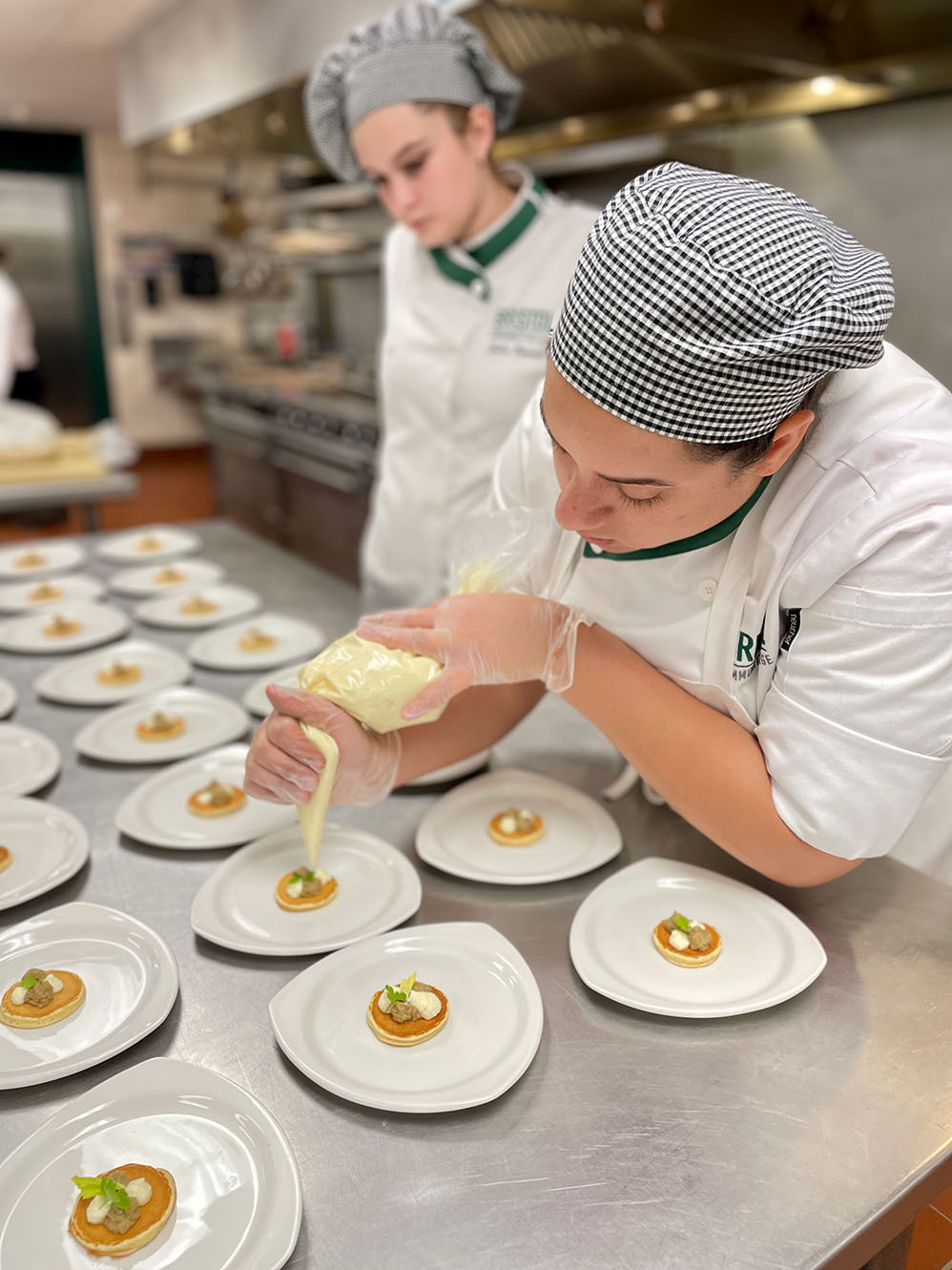 Bristol culinary arts student piping onto small pastries