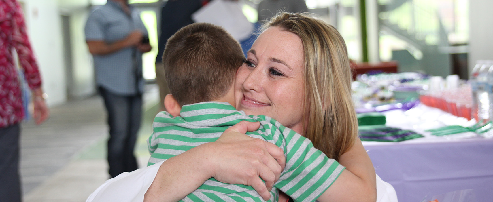 Adult student hugging child