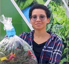 student holding a bag of produce