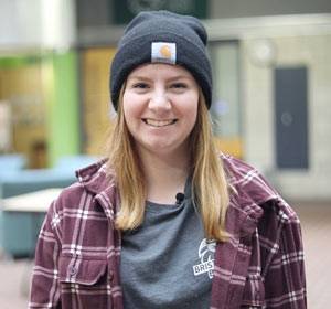 smiling person with blonde hair wearing a beanie