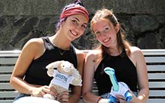 students holding stuffed animals on a bench