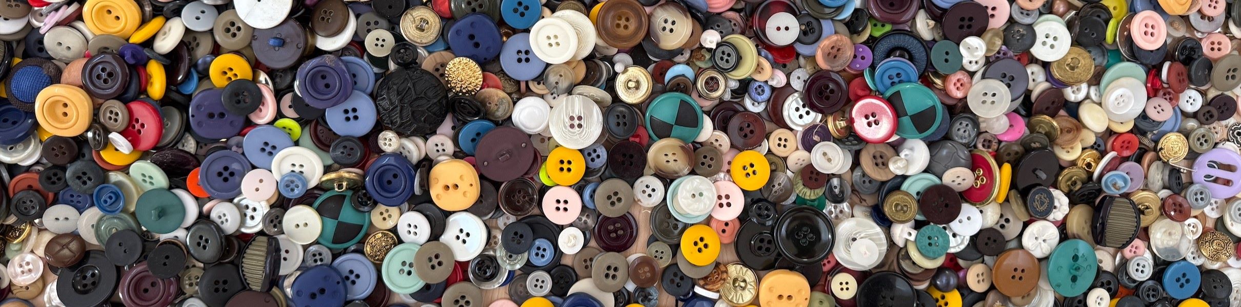 Buttons of different colors, size, and texture in a pile on the floor