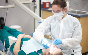 dental hygienist performing dental exam on patient