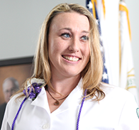 person with blonde hair and wearing white lab coat