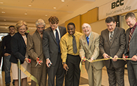 individuals standing in a line during a ribbon cutting