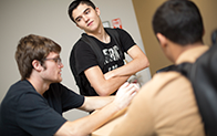 three students around table talking