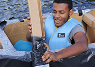 person in a duct tape and cardboard boat