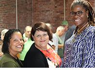 three staff members smiling at camera